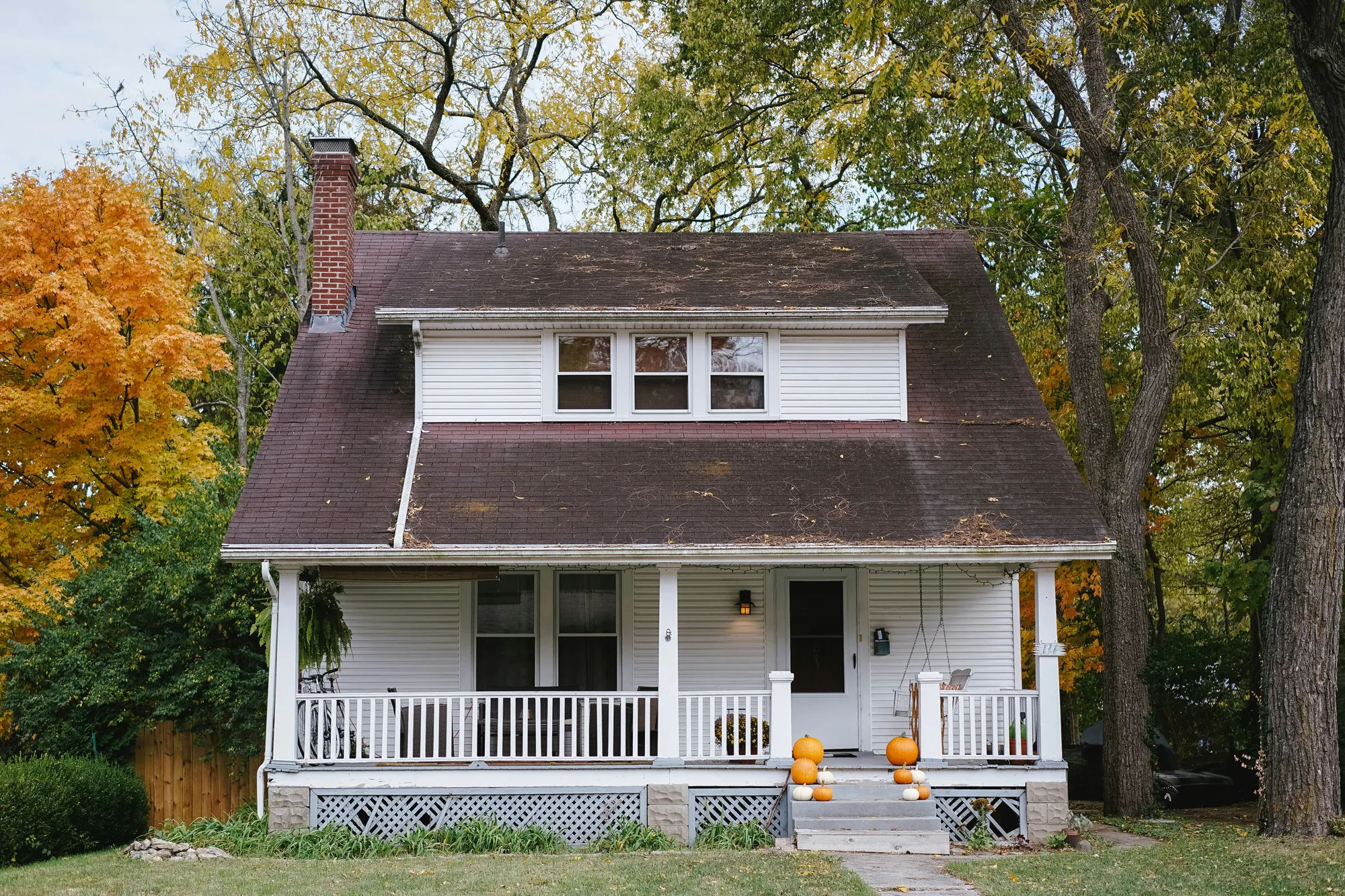 Before: a white house with a worn, mossy shingle roof